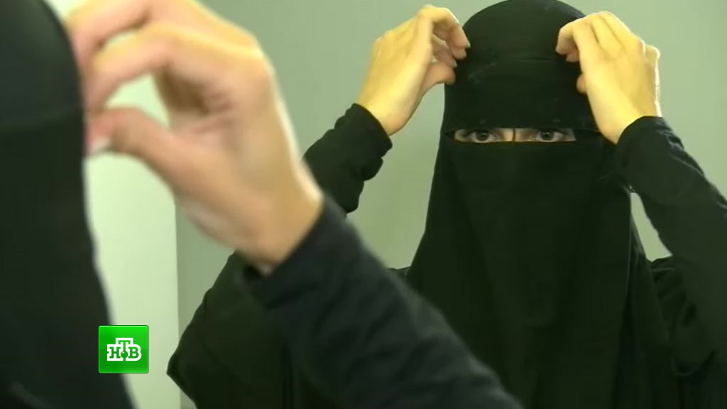 агрессивная мусульманка. хиджаб и паранджа. женщина в парандже убирается. паранджа страха. вуаль закрывающая лицо.